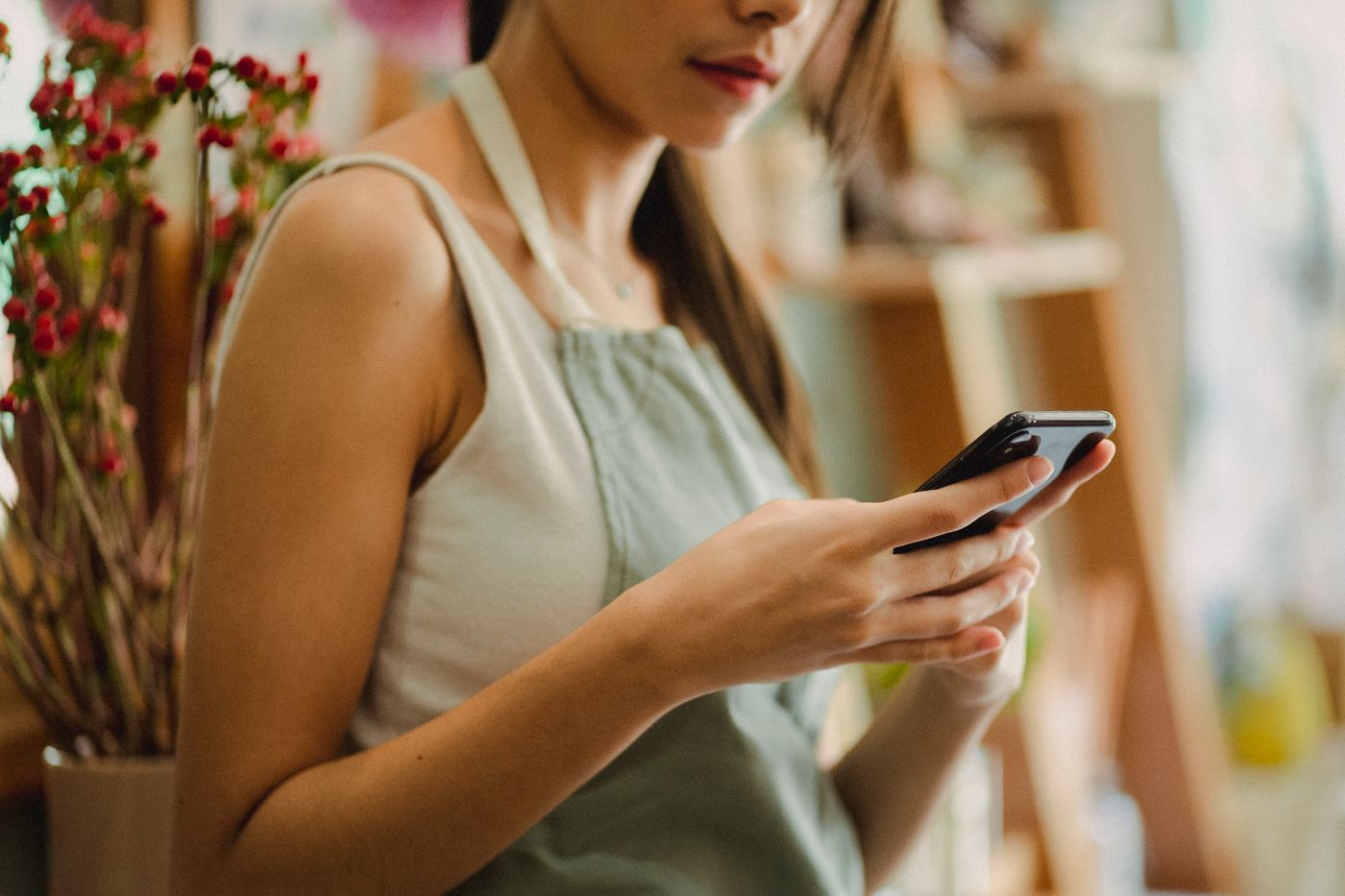A shop owner checking her phone in her shop